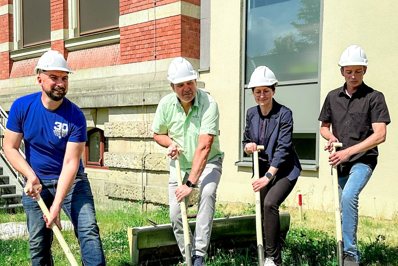 Vier Personen mit Bauhelmen beim Spatenstich am Erweiterungsbau der Parkschule 2023 